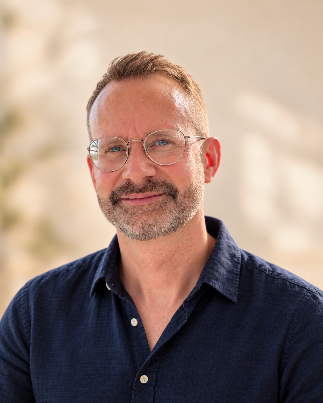 Christian Oehri, mit Brille und einem freundlichen Lächeln